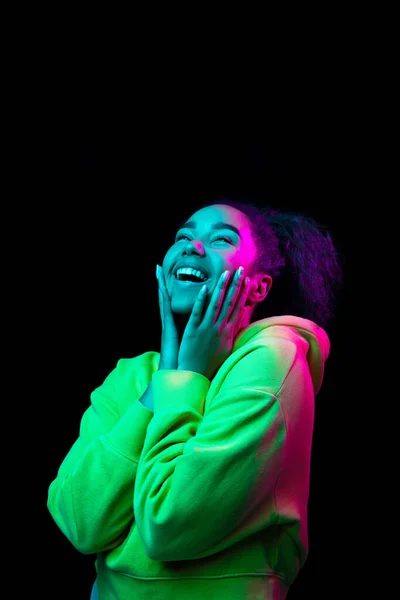 Africano-americano mulheres retrato isolado no escuro estúdio fundo em multicolorido néon luz — Fotografia de Stock