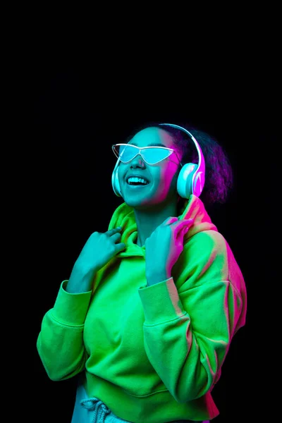 African-american womans portrait isolated on dark studio background in multicolored neon light — Stock Photo, Image