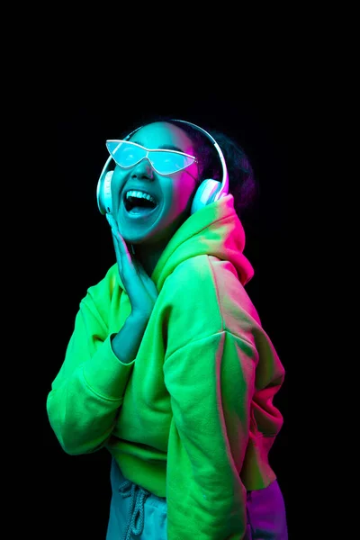 Afrika kökenli Amerikalı kadın portresi. Stüdyonun arka planında çok renkli neon ışıklarla izole edilmiş. — Stok fotoğraf