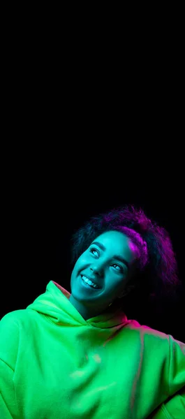 Африканско-американский портрет женщин, изолированный на темном фоне студии в разноцветном неоновом свете — стоковое фото