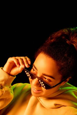 Afrika kökenli Amerikalı kadın portresi. Stüdyonun arka planında çok renkli neon ışıklarla izole edilmiş.