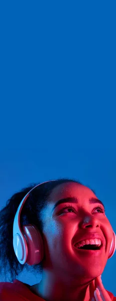 Αφροαμερικανοί γυναίκες πορτραίτο απομονωμένο σε μπλε φόντο στούντιο σε πολύχρωμο νέον φως — Φωτογραφία Αρχείου