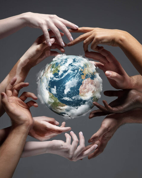 Hands holding planet Earth, close up on grey background. Environment save, taking care of nature and ecology, supporting hands concept