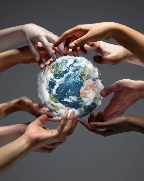 Hands holding planet Earth, close up on grey background. Environment save, taking care of nature and ecology, supporting hands concept