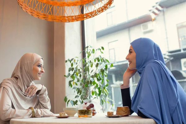 Beautiful arab women meeting at cafe or restaurant, friends or business meeting