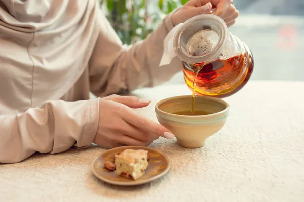 Close up vrouwelijke handen gieten thee in kopje in restaurant of cafe, dagelijkse levensstijl — Stockfoto