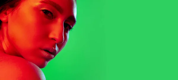 Gyönyörű keleti nő közelkép portré elszigetelt zöld háttér piros neon fény — Stock Fotó