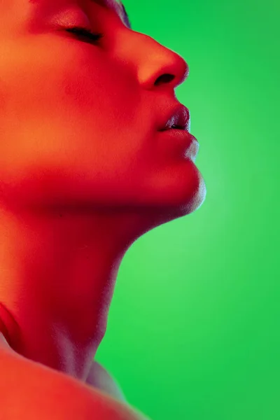 Krásná východní žena zblízka portrét izolované na zeleném pozadí v červeném neonovém světle — Stock fotografie