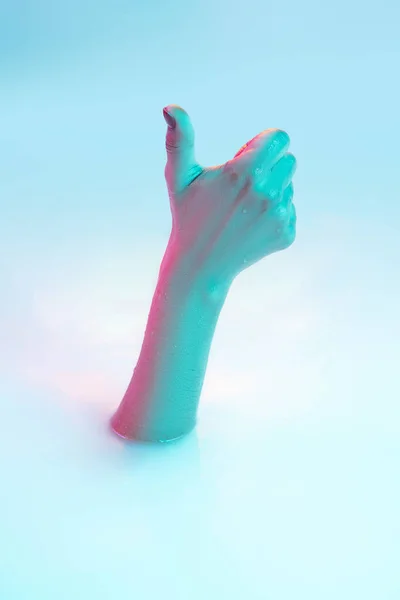 Close up female hand gesturing from the milk bath with soft glowing in neon light