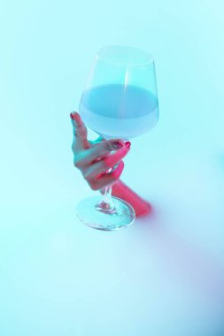 Süt banyosundan neon ışıklarıyla parlayan kadın elini kapat.