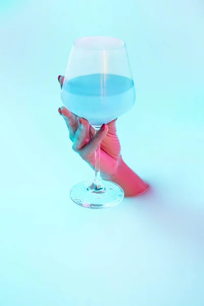 Close up female hand gesturing from the milk bath with soft glowing in neon light