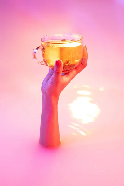 Zamknij żeńską dłoń gestykulując z kąpieli mlecznej miękkim blaskiem w neonowym świetle — Zdjęcie stockowe