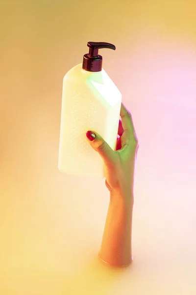 Zamknij żeńską dłoń gestykulując z kąpieli mlecznej miękkim blaskiem w neonowym świetle — Zdjęcie stockowe