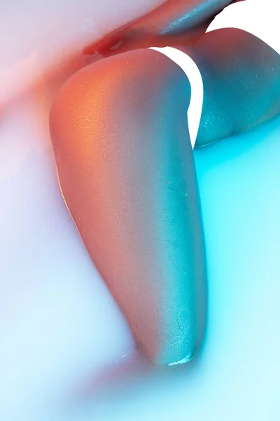 Закрыть женское тело в молочной ванне с мягким светящимся неоновым светом — стоковое фото