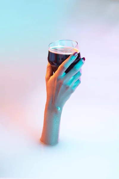 Close-up vrouwelijke hand gebaren van de melk bad met zachte gloeien in neon licht — Stockfoto