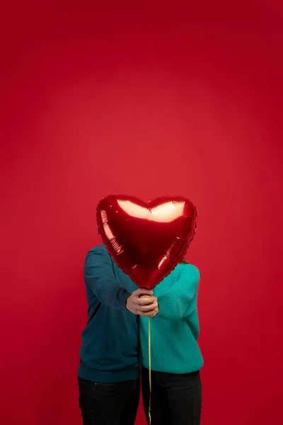 赤いスタジオの背景に愛の美しいカップル。バレンタインデー、愛と感情の概念 — ストック写真
