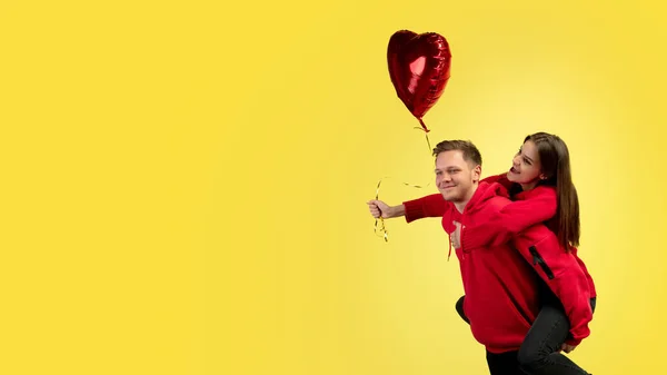 Hermosa pareja enamorada en el fondo amarillo del estudio. Día de San Valentín, concepto de amor y emociones —  Fotos de Stock