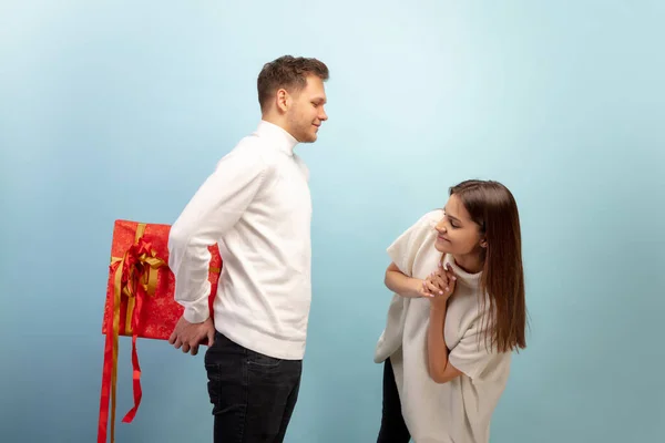 Hermosa pareja enamorada en el fondo del estudio azul. Día de San Valentín, concepto de amor y emociones —  Fotos de Stock