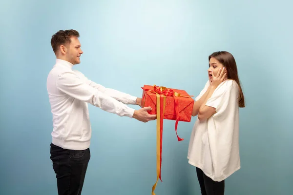 Hermosa pareja enamorada en el fondo del estudio azul. Día de San Valentín, concepto de amor y emociones —  Fotos de Stock