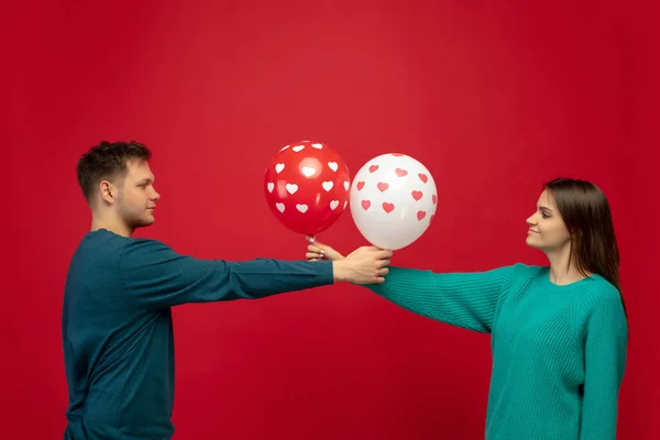 Belo casal apaixonado no fundo do estúdio vermelho. Dia dos Namorados, amor e emoções conceito — Fotografia de Stock