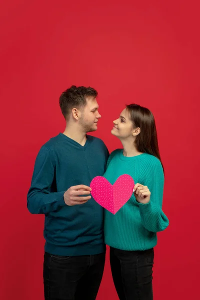 Belo casal apaixonado no fundo do estúdio vermelho. Dia dos Namorados, amor e emoções conceito — Fotografia de Stock