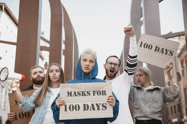 Grupo de activistas protestando, apoyando máscaras durante 100 días en Estados Unidos. Parecen enfadados, esperanzados, confiados. Banners y humo. Coronavirus. — Foto de Stock