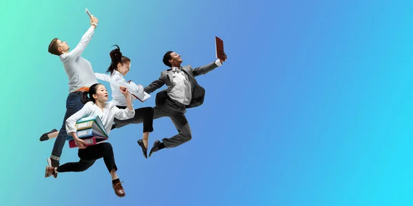 ハッピーオフィスの労働者がジャンプし、カジュアルな服やグラデーションネオン流体の背景に合わせて踊る。コピースペース付きフライヤー — ストック写真