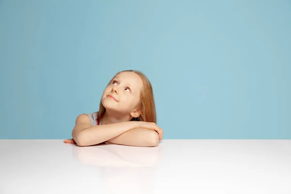 Mavi stüdyo arka planında izole edilmiş mutlu kızıl saçlı kız. Mutlu, neşeli ve samimi görünüyor. Kopyalama. Çocukluk, eğitim, duygu kavramı — Stok fotoğraf