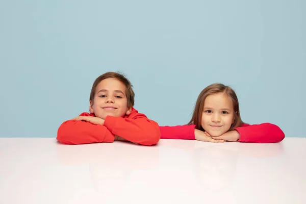 青いスタジオの背景に孤立した幸せな子供たち。見て、明るく、誠心誠意幸せ。コピースペース。子供時代教育感情概念 — ストック写真