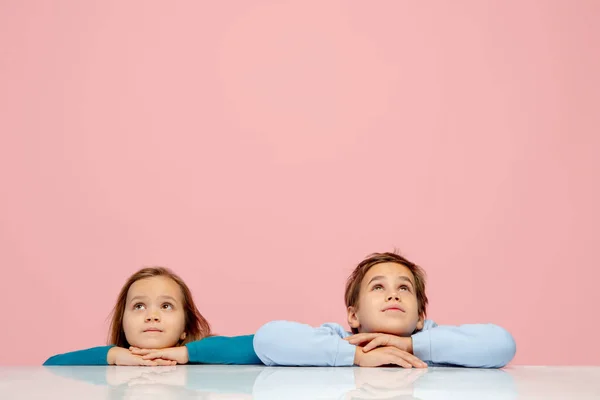 Crianças felizes isoladas no fundo do estúdio coral rosa. Pareces feliz, alegre, sincero. Espaço de cópia. Infância, educação, conceito de emoções — Fotografia de Stock