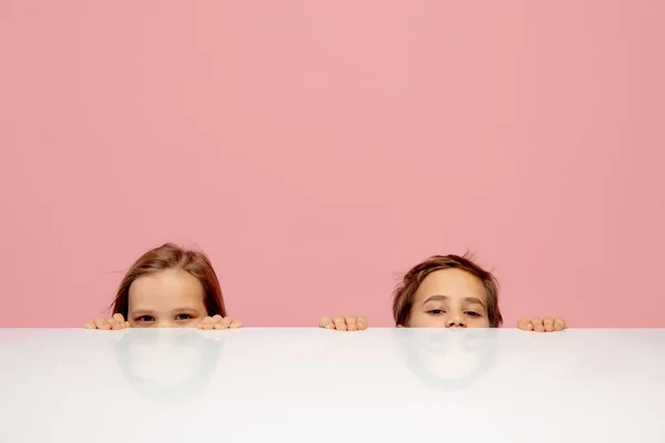 Crianças felizes isoladas no fundo do estúdio coral rosa. Pareces feliz, alegre, sincero. Espaço de cópia. Infância, educação, conceito de emoções — Fotografia de Stock