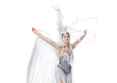 Karnaval içinde güzel bir genç kadın, beyaz stüdyo arka planında tüyleri dans eden şık bir maskeli balo kostümü. Bayram kutlaması kavramı, festival zamanı, moda