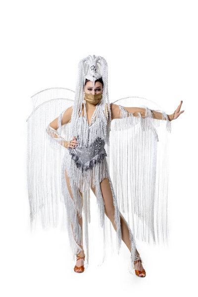 Beautiful young woman in carnival, stylish masquerade costume with feathers dancing on white studio background. Concept of holidays celebration, festive time, fashion