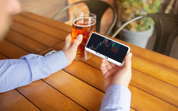 Sluit handen houden smartphone met trading informatie grafieken op het scherm. Zaken, financiën. Moderne technologie en werk. — Stockfoto