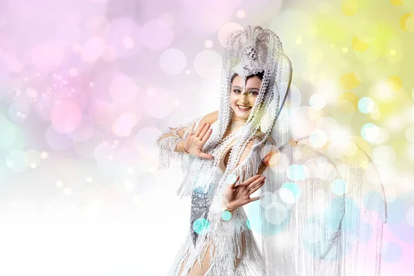 Piękna młoda kobieta w karnawale, stylowy kostium maskowy z piór tańczących na białym tle studio z lśniącym konfetti — Zdjęcie stockowe