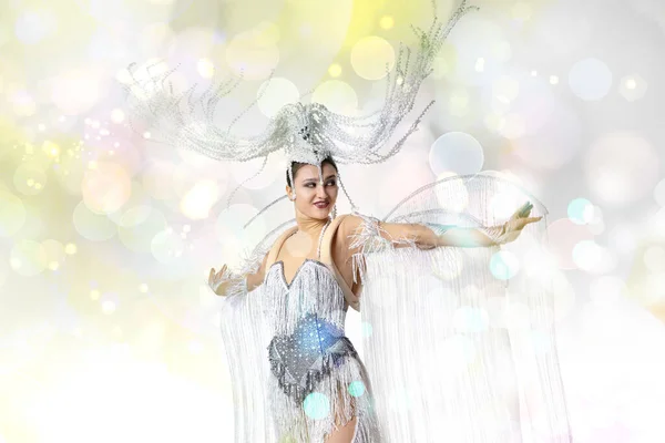 Belle jeune femme au carnaval, costume de mascarade élégant avec des plumes dansant sur fond de studio blanc avec des confettis brillants — Photo