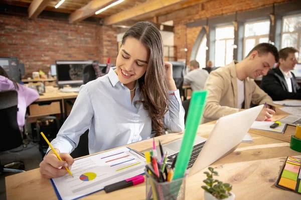 Jeunes collègues caucasiens travaillant ensemble dans un bureau en utilisant des appareils et des gadgets modernes — Photo