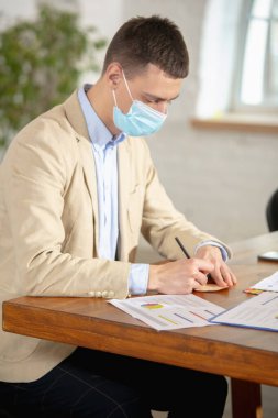 Yaratıcı toplantı sırasında modern cihazlar ve aletler kullanarak bir ofiste çalışan bir yönetici.