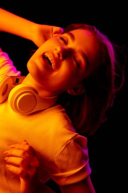 Kafkas kadın portresi, siyah stüdyo arka planında çok renkli neon ışıklarla izole edilmiş.