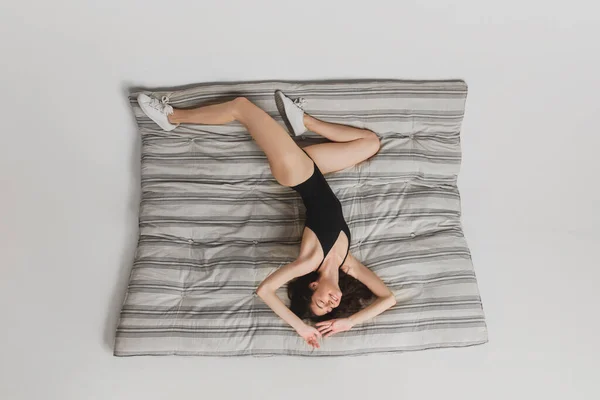 Vue de dessus beau portrait de jeune femme isolé sur fond studio matelas rayé. S'amuser, heureux, pleine longueur — Photo