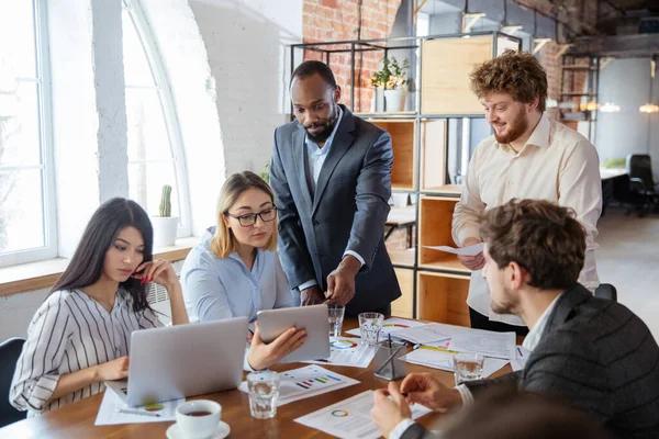 Diverso gruppo di colleghi che hanno una discussione casuale in ufficio. Dirigenti durante la discussione amichevole, resoconto mensile, incontro creativo — Foto Stock