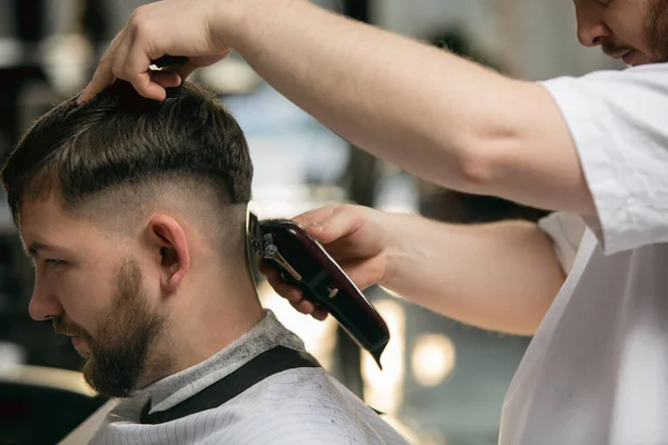 Close up master barber, stylist does the hairstyle to guy, young man. Professional occupation, male beauty concept — Stock Photo, Image