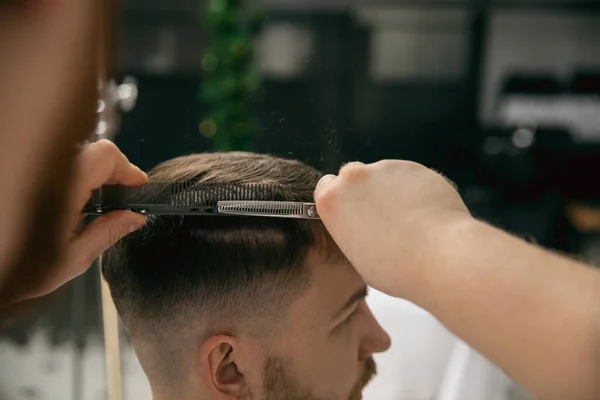 Friseurmeister aus nächster Nähe, Stylist frisiert den jungen Mann. Professionelle Beschäftigung, männliches Schönheitskonzept — Stockfoto