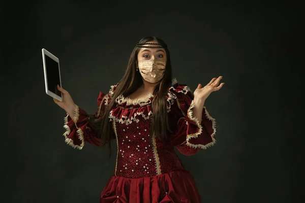 Retrato de mulher jovem medieval em roupas vintage e máscara facial dourada no fundo escuro. — Fotografia de Stock