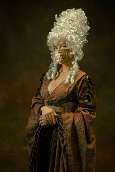 Portré középkori fiatal nő vintage ruhák és arany arc maszk sötét háttér. — Stock Fotó