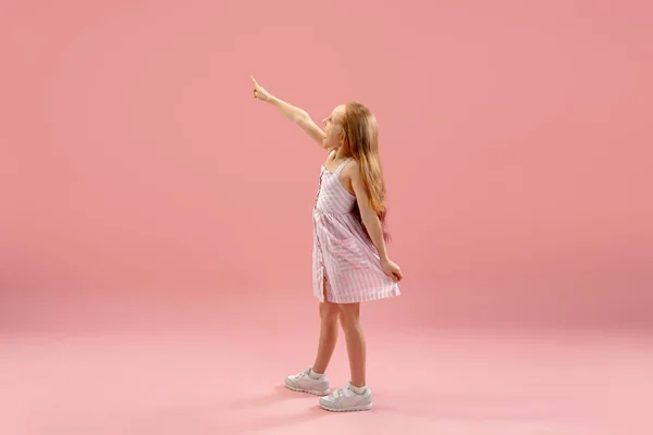 Infancia y sueño sobre el futuro grande y famoso. Bastante longhair chica aislado en coral rosa fondo —  Fotos de Stock