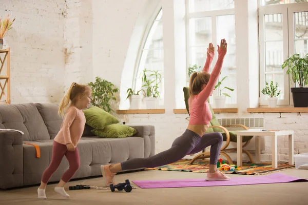 Spor yapan genç bir kadın, aerobik, evde yoga, spor yaşam tarzı. Çocuğuyla oynarken, evde spor yaparken.. — Stok fotoğraf