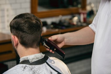 Usta berberin müşterisini kapat, saç stilini düzeltirken stilistlik yap. Profesyonel meslek, erkek güzellik konsepti