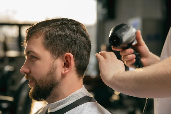 Großaufnahme des Kunden des Friseurmeisters, des Stylisten während der Frisurenpflege. Professionelle Beschäftigung, männliches Schönheitskonzept — Stockfoto