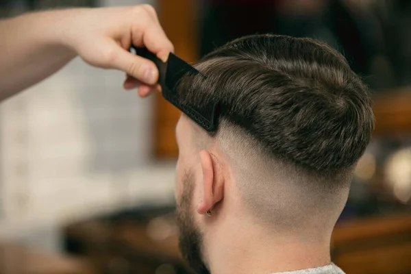 Close-up de cliente de barbeiro mestre, estilista durante o cuidado de penteado. Ocupação profissional, conceito de beleza masculina — Fotografia de Stock